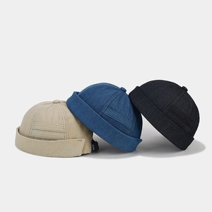 British retro denim docker hats in beige, blue, and black with a stylish letter label