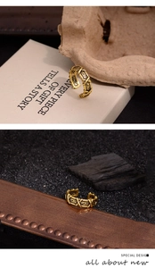 Gros plan détaillé d'une bague croisée dorée vintage avec motifs de vigne en relief