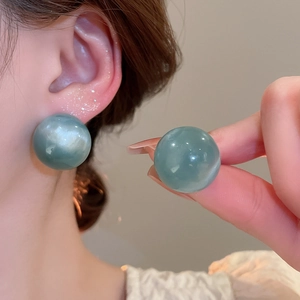 Detailed view of grey-blue resin ball stud earrings with polished marble effect texture