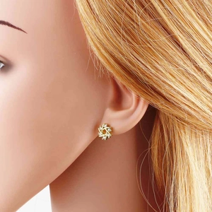 Elegant 18k gold plated flower stud earrings with white zircon stones on female model
