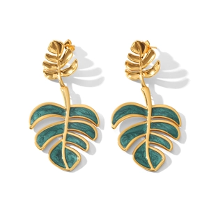 Macro detail of tropical monstera leaf earrings in gold finish with dark green enamel