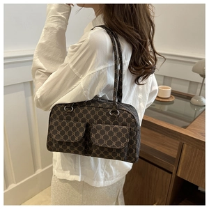 Close-up of vintage brown monogram shoulder bag with dual front flap pockets and zip details
