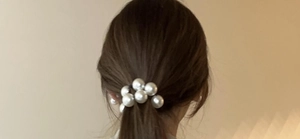 Detail view of large white pearls hair tie used as an elegant ponytail holder