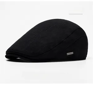 Detail of black knit beret hat showing texture and rectangular metal logo plate