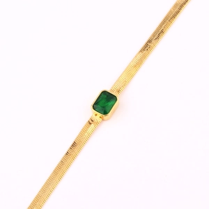Dettaglio macro della collana a serpente placcata oro 18k con gemma verde rettangolare