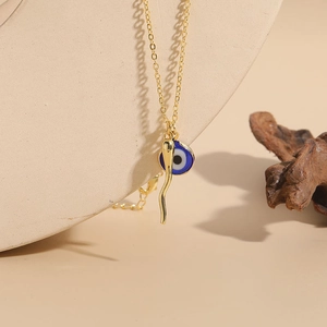 14K gold plated evil eye pendant necklace with blue glass and horn charm detail