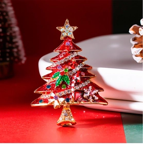 Macro detail of enamel Christmas tree brooch with colorful rhinestones and gold plating