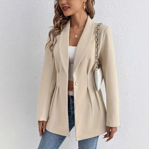 Détail de la taille ajustée plissée et bouton unique sur un blazer beige cintré