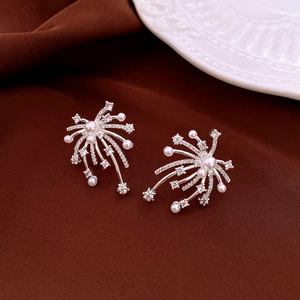 Dettaglio di orecchini a fiore in argento con strass e perle su velluto scuro