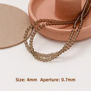 Dettaglio macro di perline in vetro traslucido marrone da 4 mm per gioielli fai da te