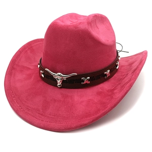 Detail view of pink suede cowboy hat featuring a leather band and silver bull head ornament