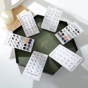 Detailed flat lay of acrylic acetate earring sets on cards inside a green jewelry box