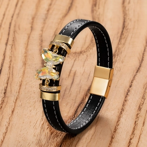 Gros plan du bracelet en cuir noir tressé avec fermoir magnétique et papillons en cristal