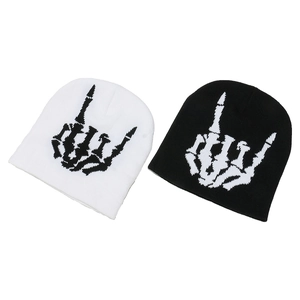 Set of black and white knit beanies featuring skeleton hand rock gesture graphic