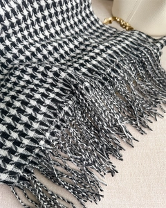 Close-up of classic black and white houndstooth scarf texture and fringe tassel details
