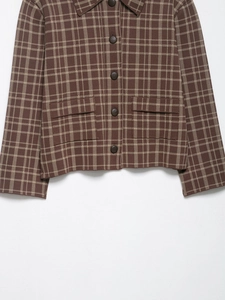 Detailansicht der braun karierten Jacke mit Strickstruktur, Frontknöpfen und zwei Taschen