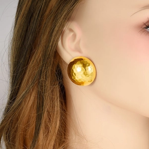 Boucles d'oreilles rondes martelées dorées minimalistes pour femme sur un mannequin