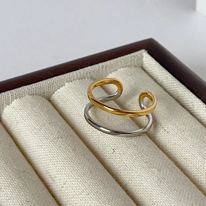 Macro shot of two-tone gold and silver layered ring on a cream velvet jewelry box