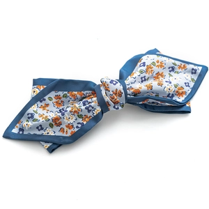 Floral print satin bow hair clip with orange and purple flowers on a blue background