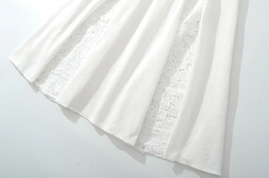 Detailed close-up of white skirt hem featuring delicate lace patchwork and cotton fabric