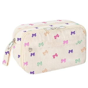 Detail of white corduroy pencil case with colorful bow patterns and dual zip pockets