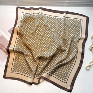 70cm square silk scarf with beige geometric pattern and brown border in a flat lay view