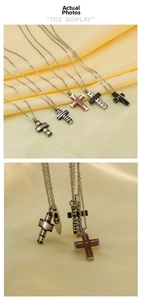 Close-up of titanium steel cross pendants in silver, black, and striped industrial design