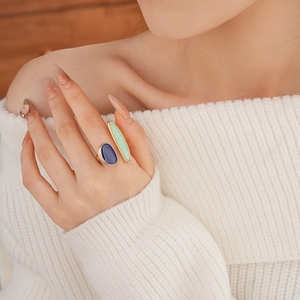 Detailed shot of gold dual-stone ring with navy blue and light green oval resin inlays