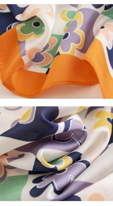 Macro detail showing vibrant floral patterns and silky texture on geometric neck scarf