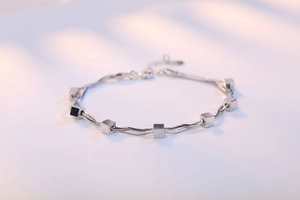 Detail of silver double snake chain bracelet with square cubes and adjustable clasp