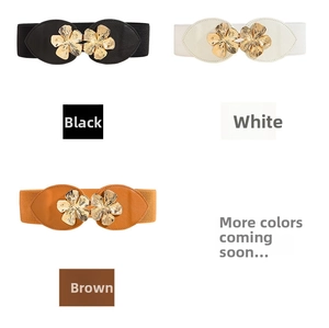 Three elastic waist belts in black white and brown with gold floral metal buckles