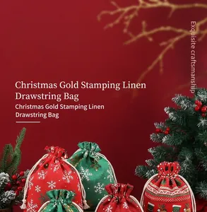 Détail de sacs de Noël en lin à cordon avec flocons et motifs de cerf dorés