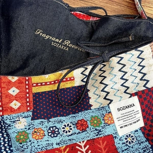 Detailed close-up of patchwork embroidery and colorful fabric on a vintage tote bag