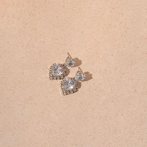 Detail of silver heart-shaped drop earrings with sparkling pavé cubic zirconia