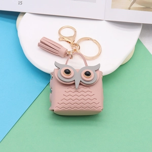 Detalle macro del monedero de búho en cuero PU rosa con borla y mosquetón de metal dorado