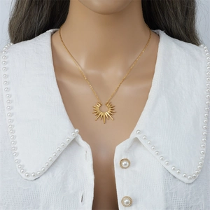 Elegant gold stainless steel starburst pendant necklace worn by a female model