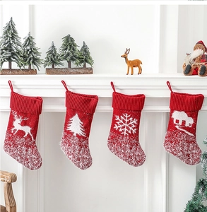 Close-up of red knit Christmas stockings with reindeer and snowflake patterns on a mantel