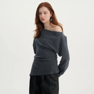 Detail of dark grey knitted fabric texture on an asymmetric off-shoulder long sleeve top