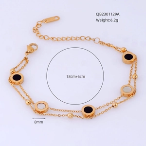 Detail of double-layer gold titanium bracelet with black and white circular charms