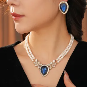 Vintage jewelry set featuring double-layer pearl necklace and blue teardrop earrings