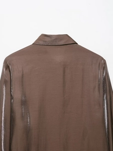 Detailed view of the back collar and shoulder of this brown satin shirt with silky luster