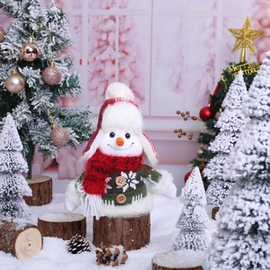 Cute Christmas snowman plush doll with knit scarf and hat sitting on wooden log scene