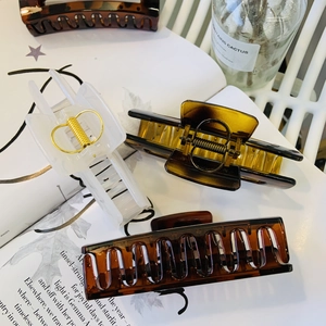 Detail of tortoise shell and cream hair claws on minimalist lifestyle background