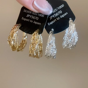 Detail of twisted texture hoop earrings in 925 silver finish gold and silver colors