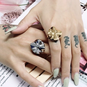 Detail von gewellten minimalistischen Ringen in Gold und Silber auf der Hand mit Textur
