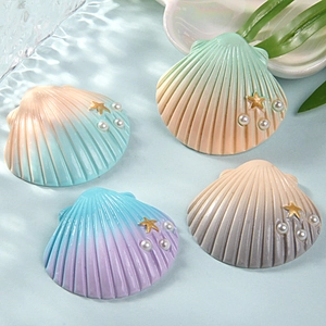 Detailed view of large resin sea shells with colorful gradients, pearls, and gold starfish