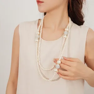 Double-layer long pearl necklace with pavé diamond spheres for a French luxury aesthetic