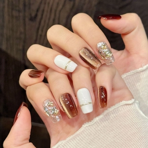 Brown and white handmade press-on nails with cat eye effect and golden star sequins