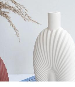 Close-up of modern matte white ceramic vase featuring a unique 3D wavy fan texture