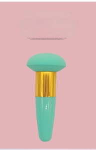 Detail view of the soft mint green mushroom head makeup sponge brush with golden ferrule